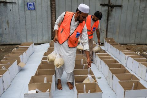 Volunteers prepare food boxes to distribute to flood victims in Peshawar on August 26.